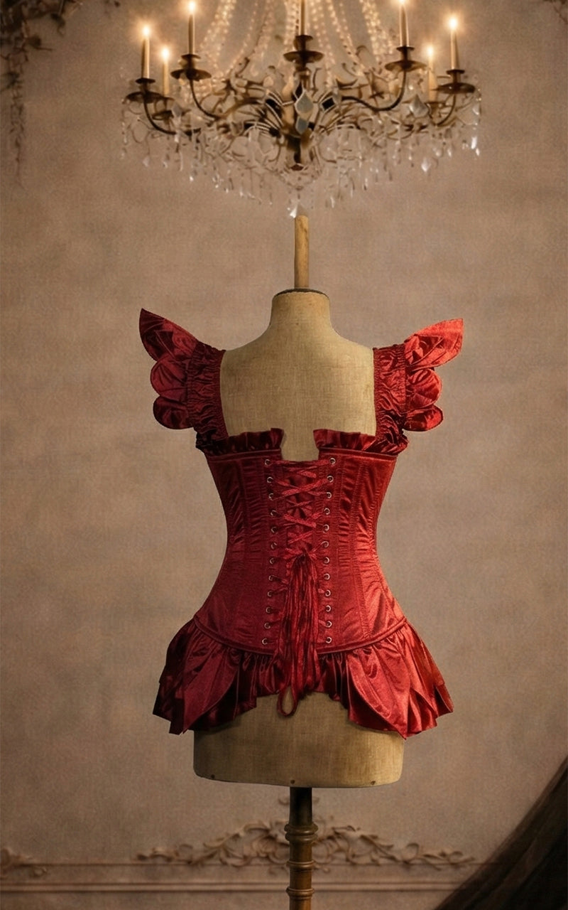 Red fairy corset  on a mannequin against a vintage wall with a chandelier - madame mortelle